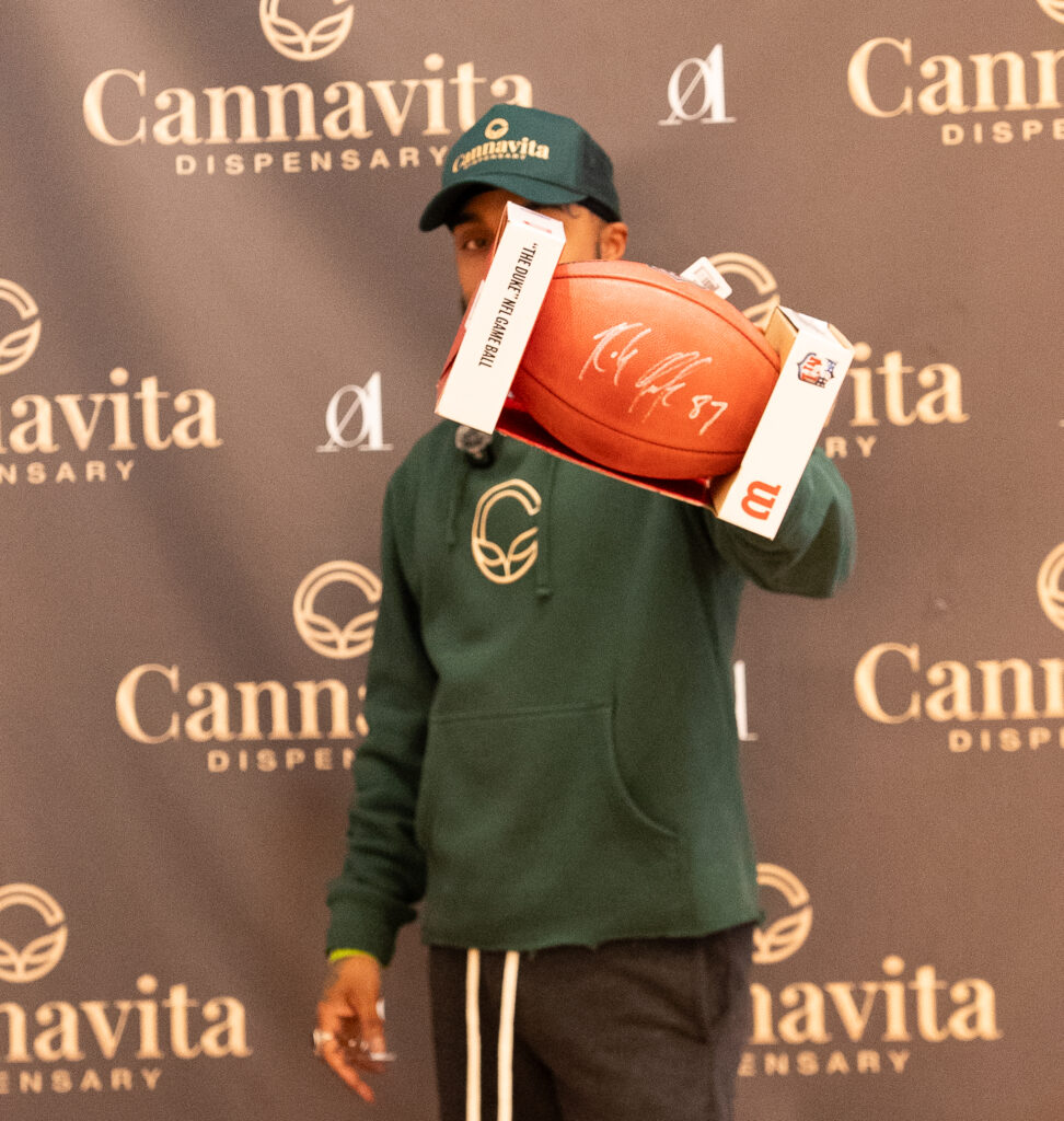 guy holding football ball for give away at cannavita